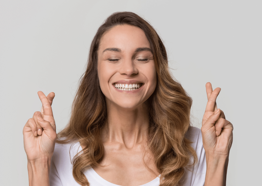 een vrouw zit met gekruiste vingers en gesloten ogen in een moment van reflectie symboliseert de zoektocht naar innerlijke rust en het belang van persoonlijke zingeving in het dagelijks leven